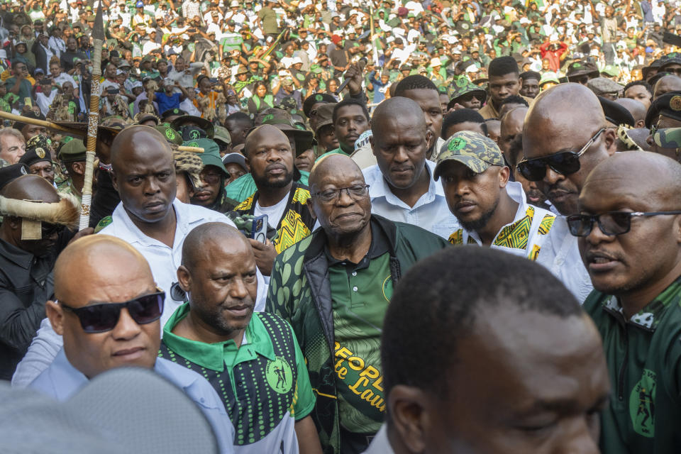 Former South African President Jacob Zuma, centre, arrives at Orlando stadium in the township of Soweto, Johannesburg, South Africa, for the launch of his newly formed uMkhonto weSizwe (MK) party's manifesto Saturday, May 18, 2024. Zuma, who has turned his back on the African National Congress (ANC) he once led, will face South African President Cyril Ramaphosa, who replaced him as leader of the ANC in a bitter battle in the general elections later in May. (AP Photo/Jerome Delay)