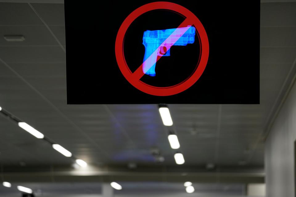 A television displays a "no guns" sign at the Transportation Security Administration security area at the Hartsfield-Jackson Atlanta International Airport on Wednesday, Jan. 25, 2023, in Atlanta. Last year saw a record number of guns intercepted at airport checkpoints across the country. The numbers have been steadily climbing and hit 6,542 last year. The head of the Transportation Safety Administration, David Pekoske, says this is a reflection of what is going on in society and in “society there are more people carrying firearms.” (AP Photo/Brynn Anderson) ORG XMIT: GABA101