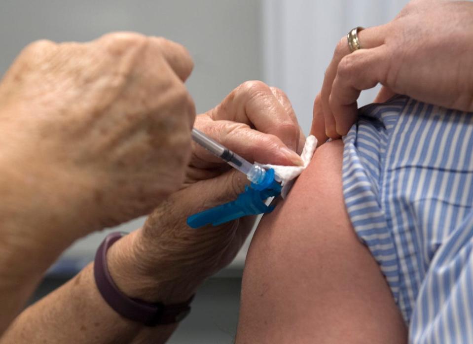 Spectrum Health's Carol Robinson, RN, administer's a Covid-19 vaccine to Dr. Marc McClelland as the first vaccine at 12:04 p.m. in Grand Rapids on Monday, Dec. 14, 2020.