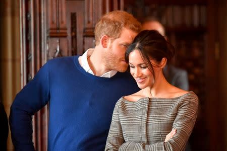 Britain's Prince Harry whispers to Meghan Markle as they watch a performance by a Welsh choir in the banqueting hall during a visit to Cardiff Castle in Cardiff, Britain, January 18, 2018. REUTERS/Ben Birchall/Pool/Files