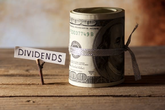 A piece of paper with the word dividends written on it next to a bundle of money