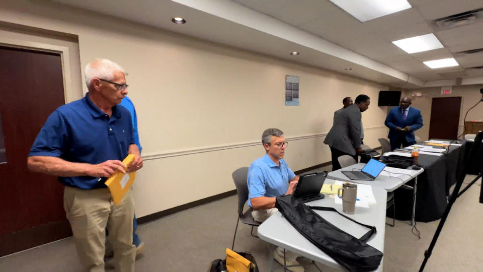 <em>Bennettsville City Attorney Mason King (seated) searches through the S.C. Freedom of Information Act to research whether city council may have violated the Act by going into executive session when it didn’t have a legal right to do so, based off the published agenda item. Councilman Bill Jennings looks on before leaving to meet privately with council in a nearby room. (WJZY Photo/Jody Barr)</em>