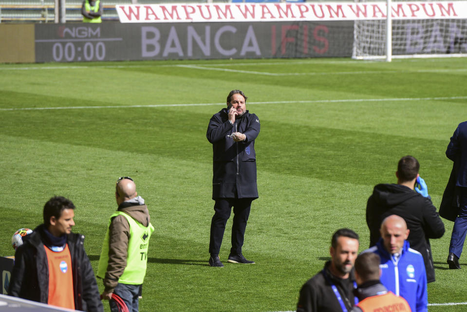 Parma's Sport's manager Daniele Faggiano, center, speaks on a phone moments before a Serie A soccer match between Parma and Spal was scheduled to be played, in Parma, northern Italy, Sunday, March 8, 2020. Parma and Spal players were ready to enter the field at Ennio Tardini stadium in Parma when they received the news that Italy’s sports minister Vincenzo Spadafora said that the country’s football federation should consider suspending the games. (Piero Cruciatti/LaPresse via AP)
