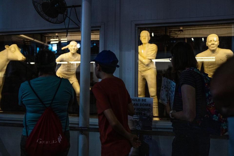 Fairgoers stop to view the butter sculptures, the cow, Caitlin Clark, Kurt Warner and Jack Trice, on the first day of the Iowa State Fair, on Aug. 10.<span class="copyright">Kelsey Kremer—The Register/Reuters</span>