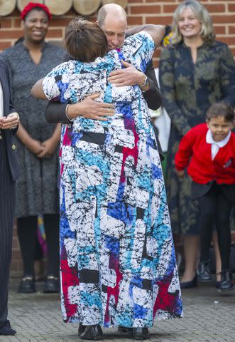 <p>Zak Hussein / SplashNews</p> Prince William shares a hug in Cardiff, Wales on Oct. 3