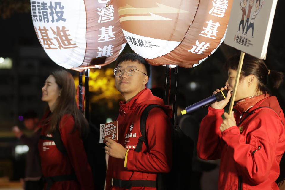 Hong Tsun-ming, center, a Taiwanese of Hong Kong descent, participates in its own political party's propaganda campaign at a night market in Taichung city, Central Taiwan, on Nov. 30, 2023. As Taiwan’s presidential election approaches, many immigrants from Hong Kong, witnesses to the alarming erosion of civil liberties at home, are supporting the ruling Democratic Progressive Party. (AP Photo/Chiang Ying-ying)