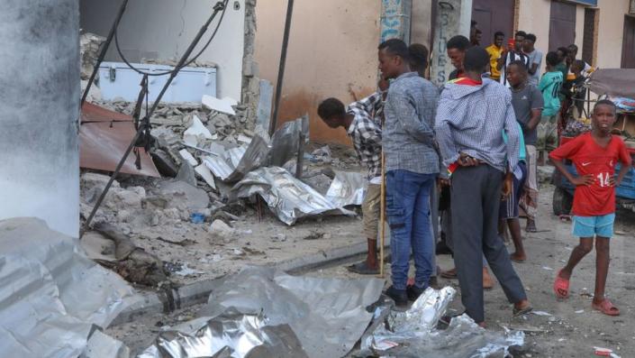 Residents pause to assess the damage at the site of an attack at the Palm Beach Hotel in Mogadishu on June 10.