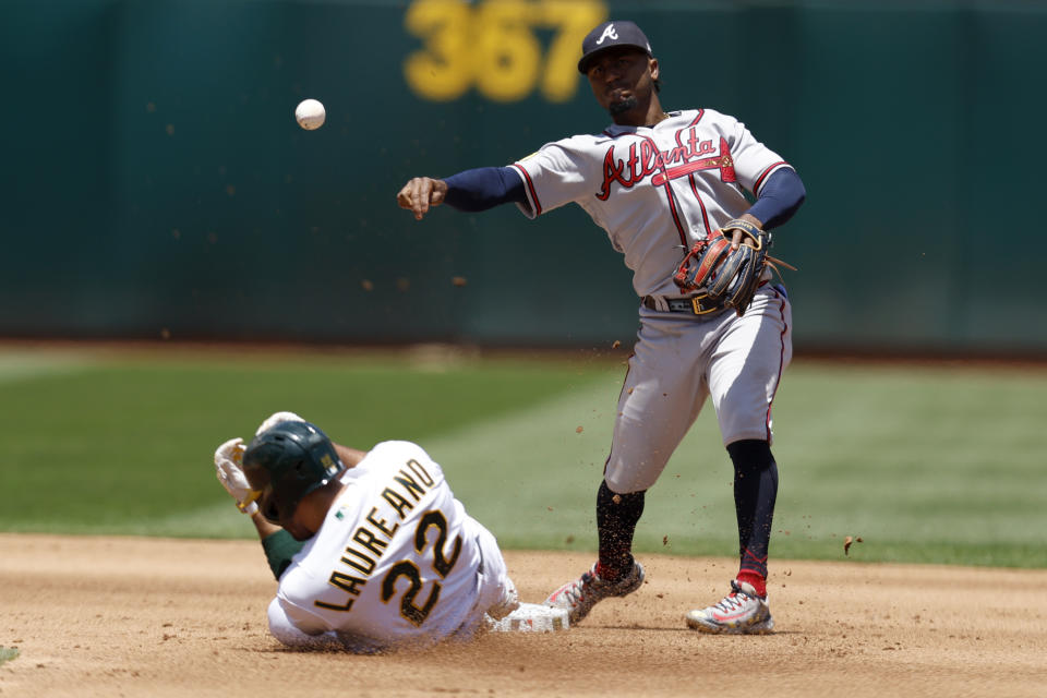 Atlanta Braves second baseman Ozzie Albies, right, throws to first as Oakland Athletics' Ramon Laureano (22) slides into second on a double play hit by Aledmys Diaz during the fourth inning of a baseball game in Oakland, Calif., Thursday, May 31, 2023. (AP Photo/Jed Jacobsohn)