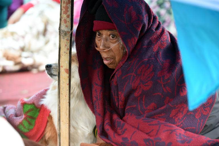 Nepalese patient Sanu Ranjitkar breathes oxygen from a cylinder under a makeshift shelter in Kathmandu, on April 27, 2015