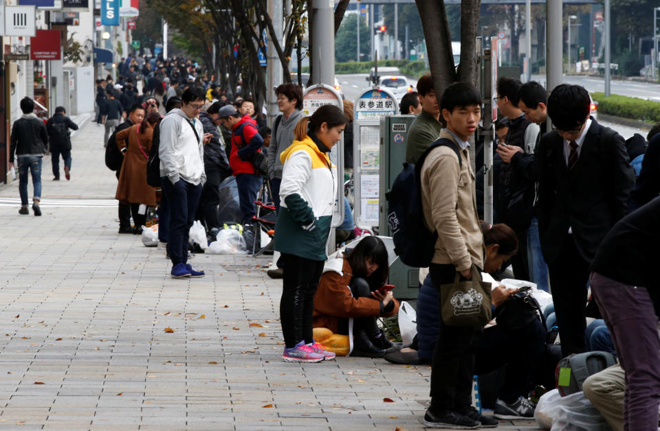 Customers wait in queue for the release of Apple’s new iPhone X outside the Apple Store in Tokyo