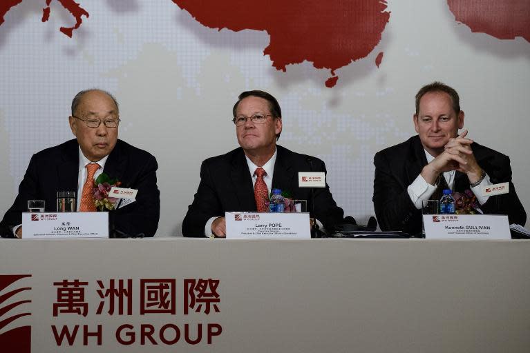 (L-R) Executive director and chairman of WH Group, Wan Long, executive director and president of Smithfield, Larry Pope and Smithfield chief financial officer, Kenneth Sullivan attend a press conference in Hong Kong on April 14, 2014