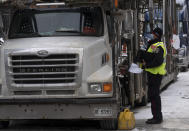 A police officer speaks with a trucker as he distributes a notice to protesters, Wednesday, Feb. 16, 2022 in Ottawa. Ottawa’s police chief was ousted Tuesday amid criticism of his inaction against the trucker protests that have paralyzed Canada's capital for over two weeks, while the number of blockades maintained by demonstrators at the U.S. border dropped to just one. (Adrian Wyld /The Canadian Press via AP)