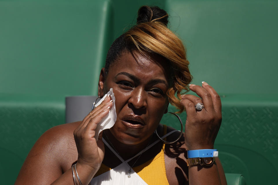 A spectator wipes her face to cool off at the U.S. Olympic Track and Field Trials Friday, June 25, 2021, in Eugene, Ore. (AP Photo/Charlie Riedel)