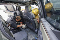 Trevor Donahoo, Engineering Testing Technician, connects testing equipment inside the Rivian cab during a crash test research by the U.S. Army Engineer Research and Development Center and the University of Nebraska-Lincoln's Midwest Roadside Safety Facility on Oct. 12, 2023 in Lincoln, Neb. Preliminary tests point to concerns that the nation’s roadside guardrails are no match for new heavy electric vehicles. (Craig Chandler/University of Nebraska via AP)