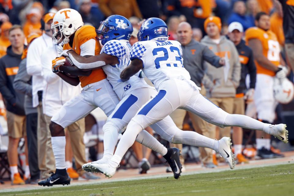 Tennessee tight end Dominick Wood-Anderson (4) is driven out of bounds after catching by Kentucky safety Mike Edwards (7) and safety Tyrell Ajian (23) in the first half of an NCAA college football game Saturday, Nov. 10, 2018, in Knoxville, Tenn. (AP Photo/Wade Payne)