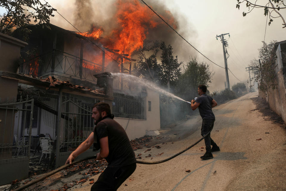 Freiwillige versuchen in der vergangenen Woche, ein brennendes Haus in Menidi nahe Athen zu löschen. (Bild: REUTERS/Elias Marcou)