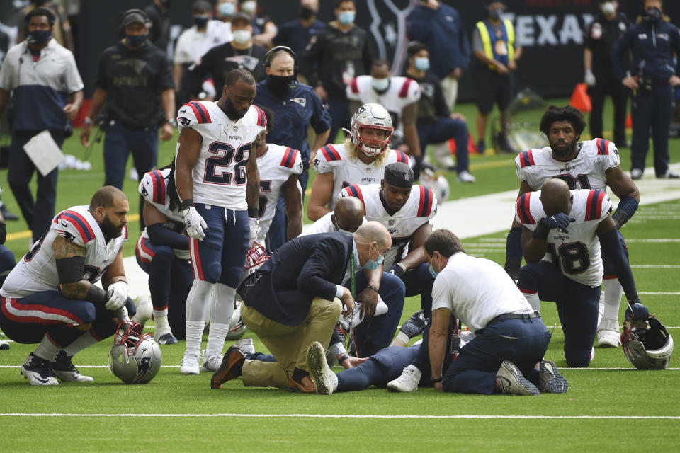 New England Patriots players kneel as teammate Rex Burkhead is attended to after he was injured during a run against the Houston Texans during the second half of an NFL football game, Sunday, Nov. 22, 2020, in Houston. (AP Photo/Eric Christian Smith)