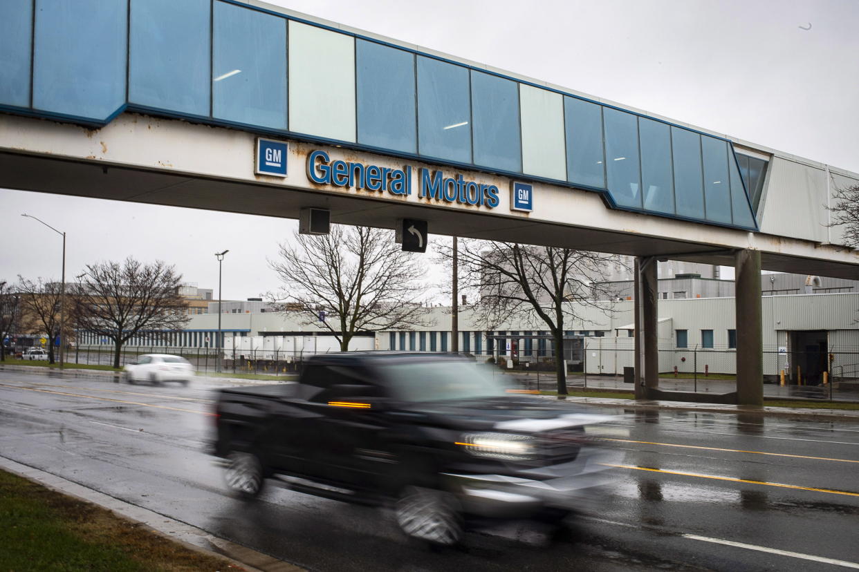 A vehicle passes under a sign at the Oshawa's General Motors plant Monday, Nov. 26, 2018, in Oshawa, Ontario. General Motors will lay off thousands of factory and white-collar workers in North America and put five plants up for possible closure as it restructures to cut costs and focus more on autonomous and electric vehicles. General Motors is closing the Oshawa plant. (Eduardo Lima/The Canadian Press via AP)