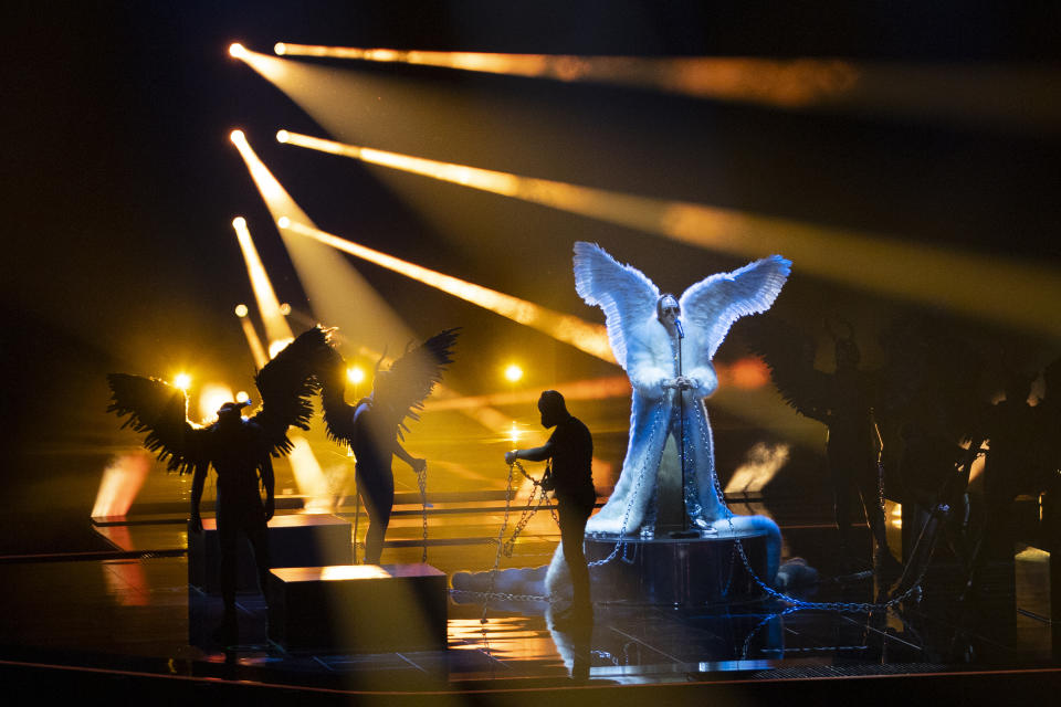 In this photo taken on May 12, 2021, a man untangles the chains as Norway's Tix rehearses his song Fallen Angel at the Eurovision Song Contest at Ahoy arena in Rotterdam, Netherlands. After last year’s Eurovision Song Contest was canceled amid the global COVID-19 pandemic, it is roaring back to life with coronavirus bubbles added to its heady mix of music and camp. Bands and singers from 39 countries are competing in the Dutch port city of Rotterdam for the coveted title that can be a springboard to a global career or a fleeting taste of flame. (AP Photo/Peter Dejong)