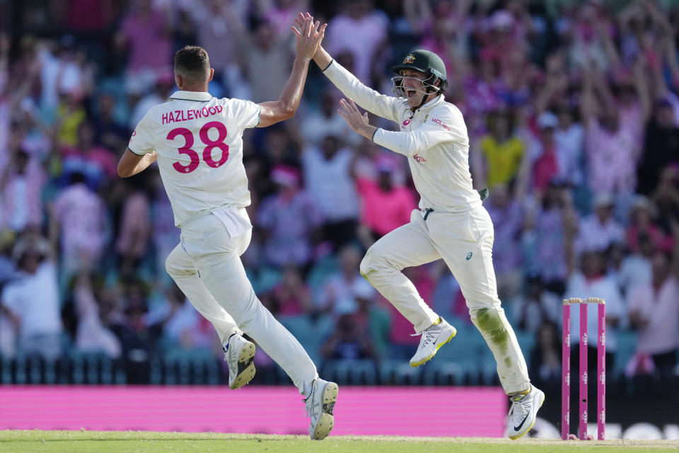 Australia's Josh Hazlewood, left, celebrates with teammate Australia's Marnus Labuschagne after taking the wicket of Pakistan's Agha Salman on the third day of their cricket test match in Sydney, Friday, Jan. 5, 2024. (AP Photo/Rick Rycroft)