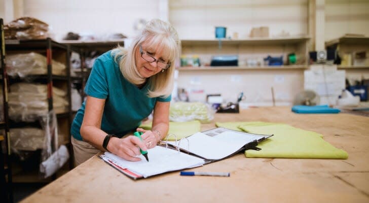 businesswoman-doing-paperwork-in-factory-SmartAsset