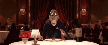 Anton Ego from "Ratatouille" looks surprised with a fork mid-air at a restaurant