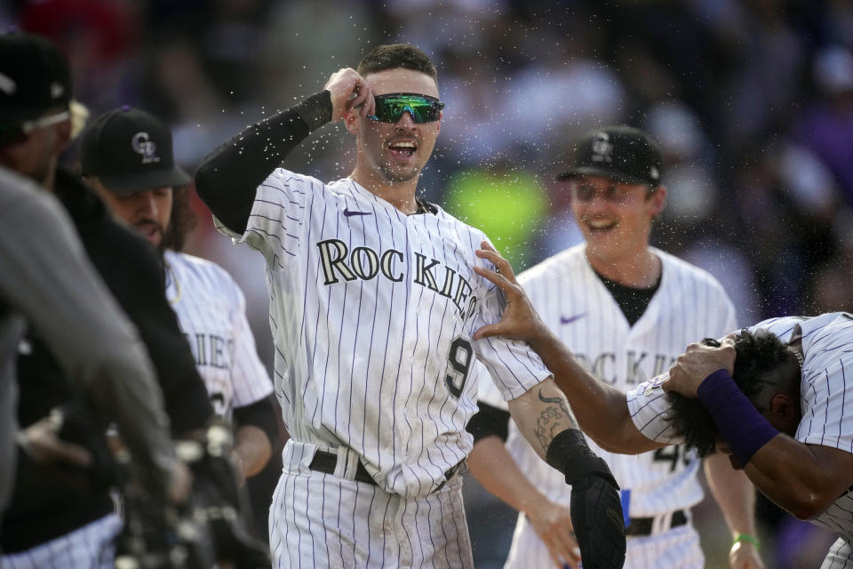 Colorado Rockies' Brenton Doyle (9) is congratulated after scoring the winning run on a wild pitch by Minnesota Twins relief pitcher Jordan Luplow in the 11th inning of a baseball game Sunday, Oct. 1, 2023, in Denver. (AP Photo/David Zalubowski)