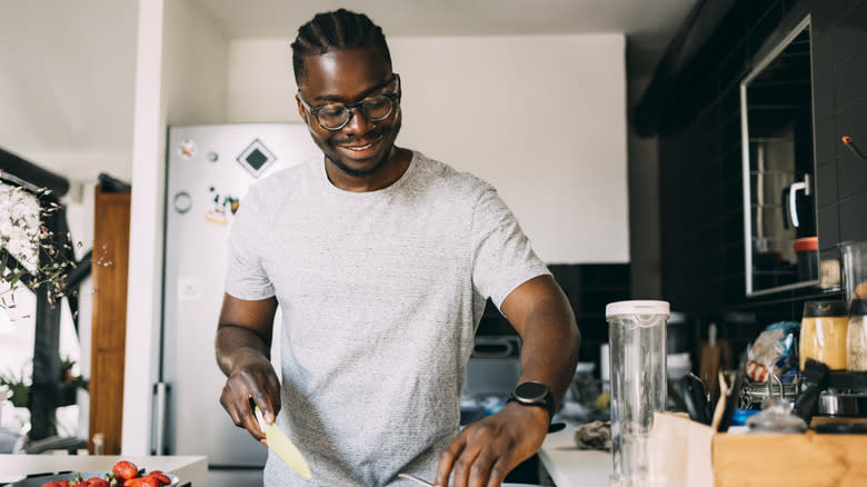 Man chopping strawberries in the kitchen