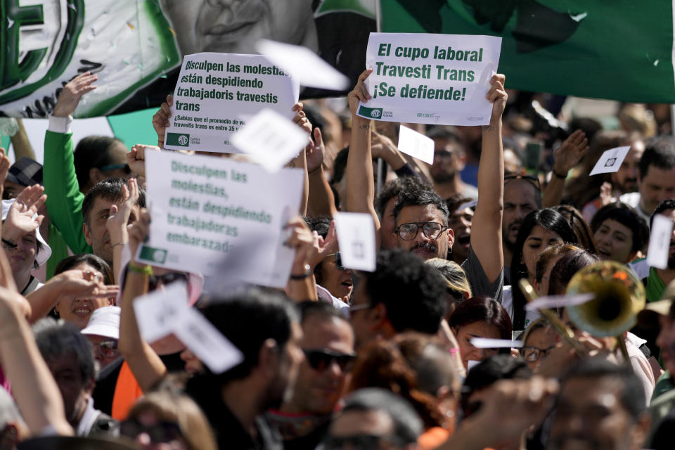 Ariel Heredia, que se identifica como no binario, muestra un cartel a favor del cupo laboral trans en una manifestación que reclama la reincorporación de empleados públicos despedidos, a las afueras del Ministerio de Economía en Buenos Aires, Argentina, el viernes 5 de abril de 2024. Heredia fue despedido del desmantelado Ministerio de las Mujeres, como parte de las medidas de austeridad del gobierno del presidente ultraliberal Javier Milei. (AP Foto/Natacha Pisarenko)