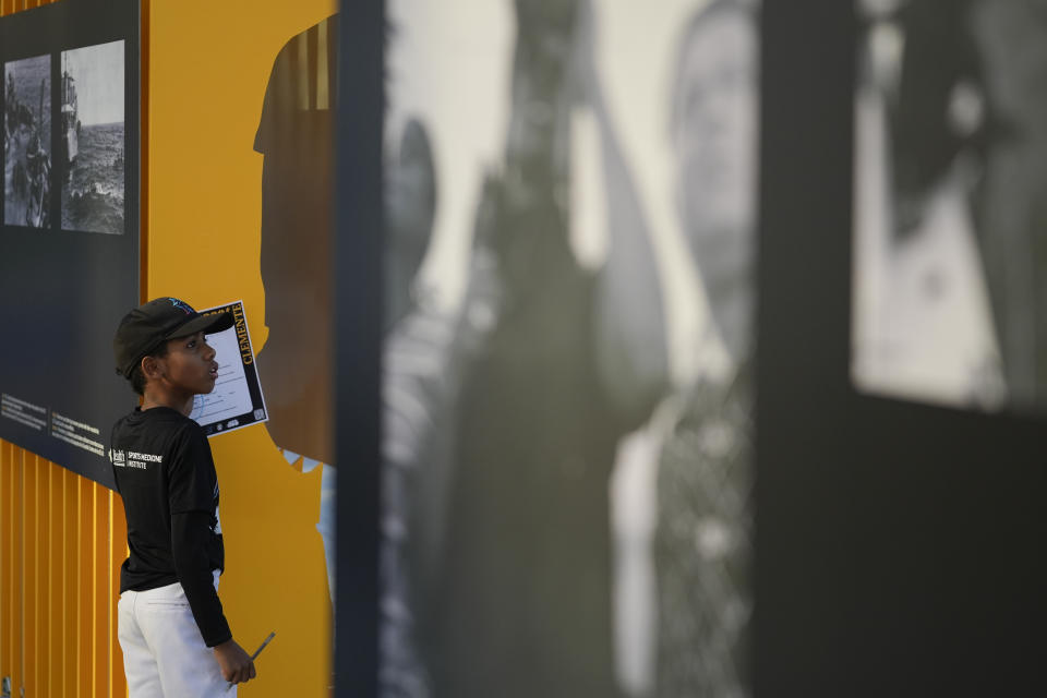 Jesus Vega, 8, fills in a worksheet on the life of late Major League Baseball player Roberto Clemente, as kids from the Marlins Nike RBI youth sports program visit a traveling exhibit titled "3000," in a nod to Clemente's 3000 career hits, at Miami Marlins' loanDepot Park in Miami, Wednesday, Jan. 31, 2024. The tribute to the Pittsburgh Pirates outfielder will be on display at the park during baseball's Caribbean Series, which runs from Feb. 1 through Feb. 9. (AP Photo/Rebecca Blackwell)