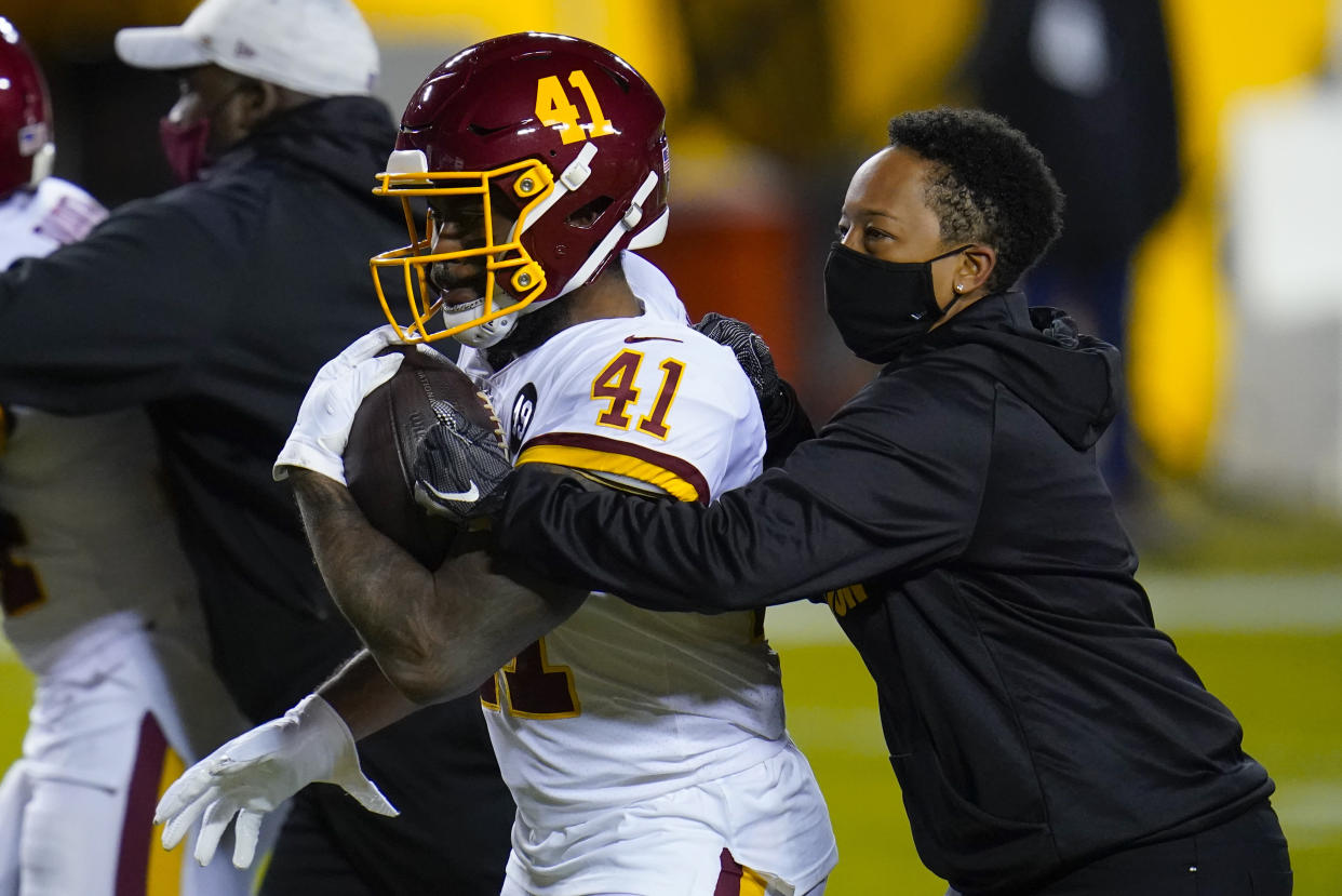 Full-year coaching intern Jennifer King, right, works with Washington Football Team running back J.D. McKissic (41) before the team's NFL wild-card playoff football game against the Tampa Bay Buccaneers, Saturday, Jan. 9, 2021, in Landover, Md. (AP Photo/Julio Cortez)