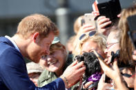 <p>In an adorable moment, Harry reaches out to pet a puppy outside the hospital. </p>