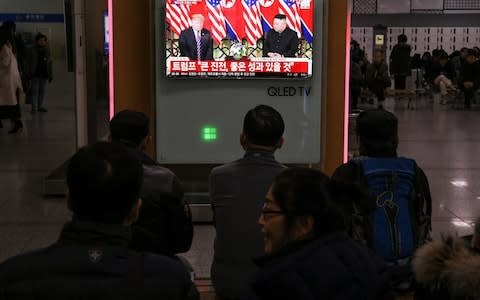 A television screen shows a news broadcast of North Korea's leader Kim Jong Un meeting with US President Donald Trump in Hanoi, at a railway station in Seoul - Credit: JUNG YEON-JE/AFP/Getty Images