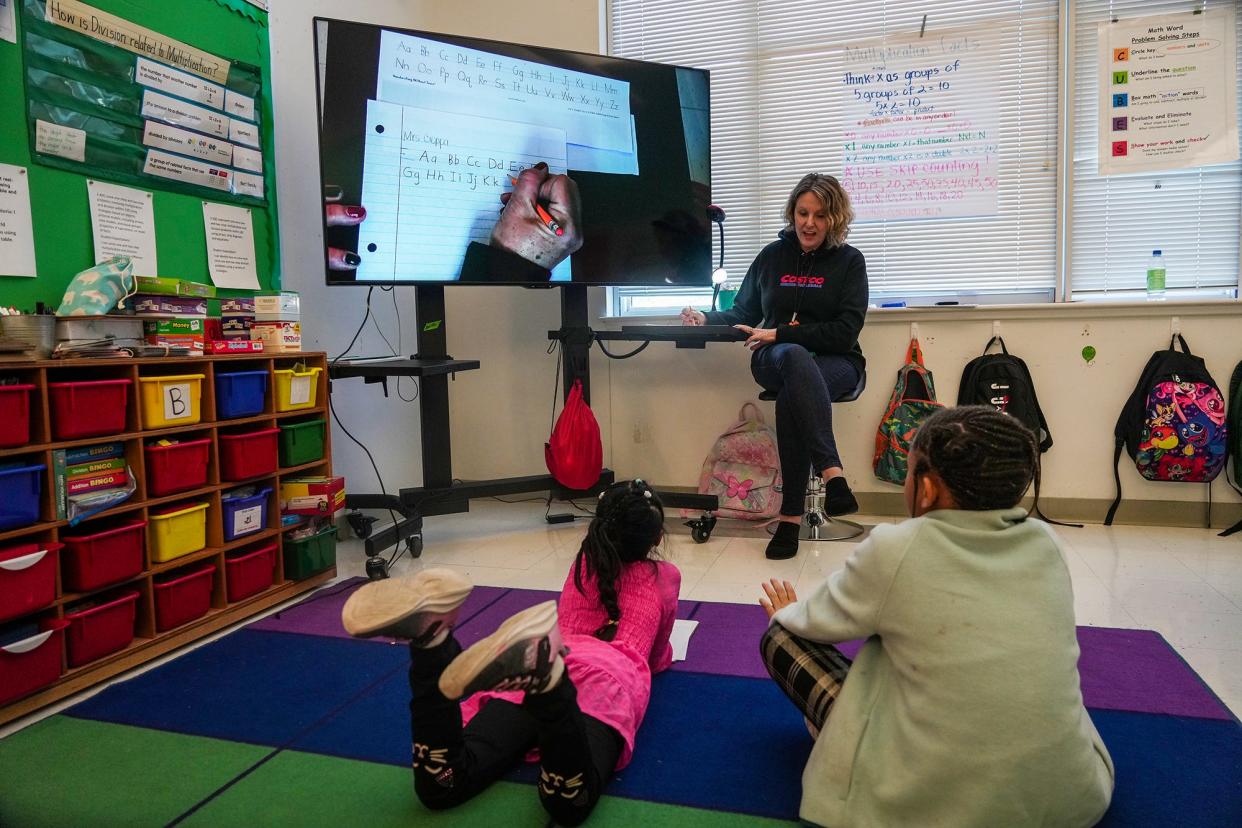 Cynthia Cioppa discusses penmanship with her Pickle Elementary School students during class in December. According to new data from the nonprofit Children at Risk, schools are still seeing lingering challenges caused by time away from in-person instruction during the COVID-19 pandemic.