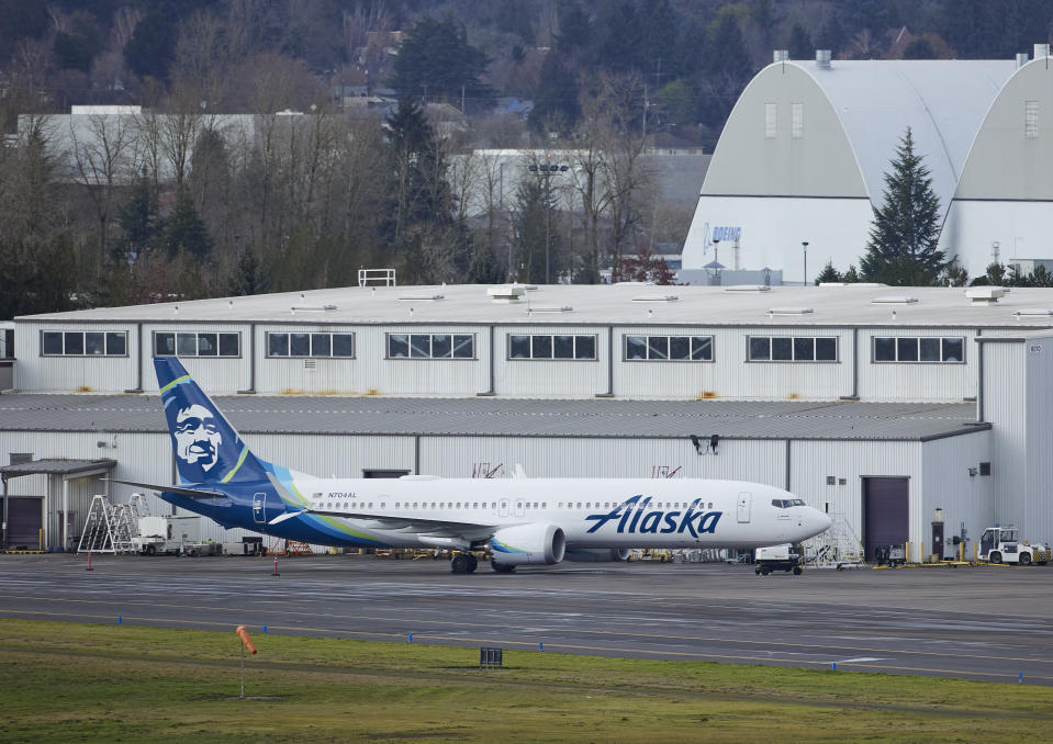 Alaska Airlines N704AL, a 737 Max 9 which made an emergency landing at Portland International Airport after a part of the fuselage broke off mid-flight on Friday, is parked at a maintenance hanger in Portland, Ore., Saturday, Jan. 6, 2024. (AP Photo/Craig Mitchelldyer)