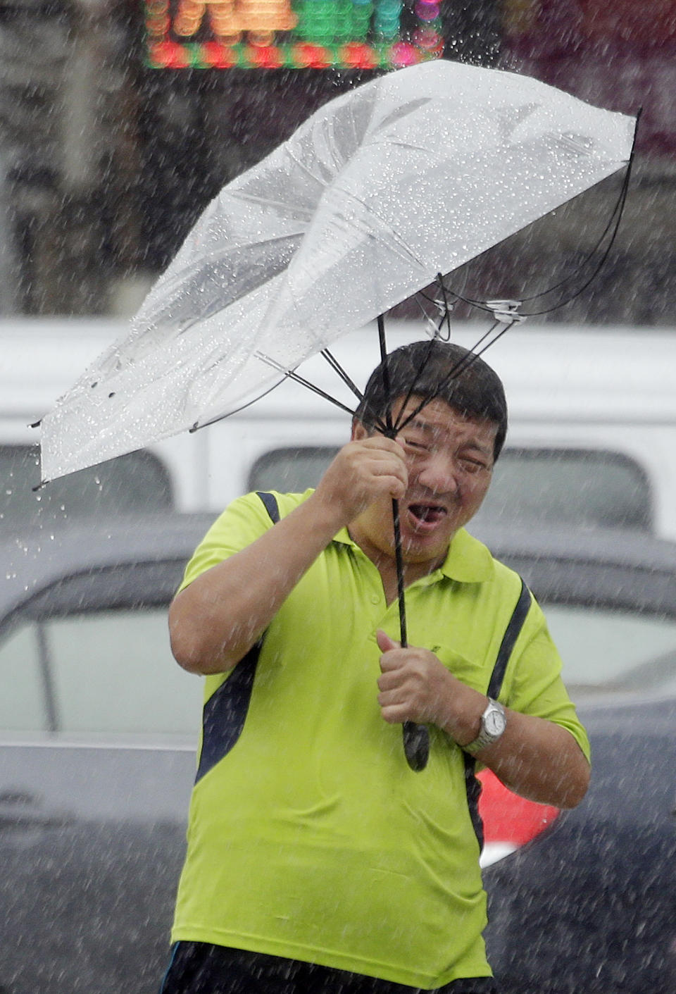 A Taiwanese man holds an umbrella against powerful gusts of wind generated by typhoon Lekima in Taipei, Taiwan, Friday, Aug. 9, 2019. (AP Photo/Chiang Ying-ying)