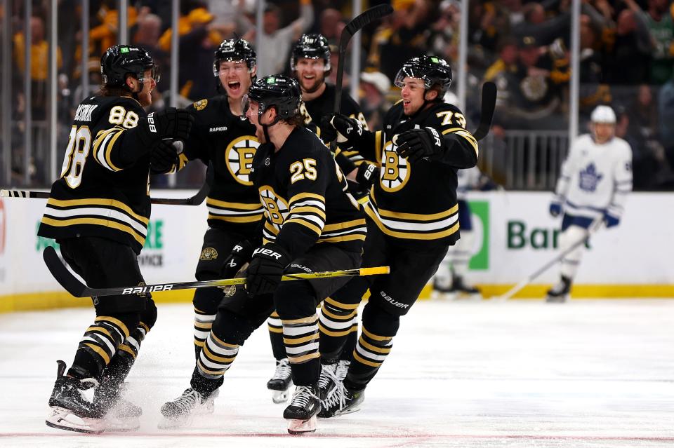 Boston Bruins forward David Pastrnak (88) celebrates with teammates Brandon Carlo (25), Charlie McAvoy (73) and John Beecher after scoring the game-winning goal against the Toronto Maple Leafs during overtime to win Game 7 of the first round of the Stanley Cup playoffs Saturday night at TD Garden.
