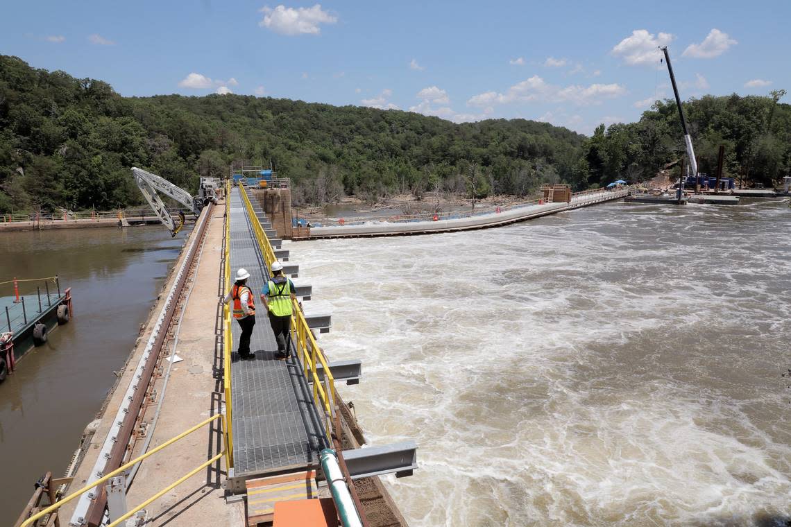 Christy Churchill, recreation planner for Duke, right, and Michael Brissie, manager of generation project engineering for Duke stand on a platform over the Catawba River where crews are bringing water back to two river channels.