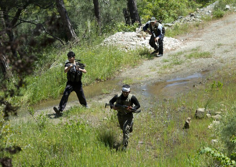 Rebel fighters from the al-Ezz bin Abdul Salam Brigade attend a training session at an undisclosed location near the al-Turkman mountains, in Syria's northern Latakia province, on April 24, 2013. Lebanon's Shiite Hezbollah movement came under increasing pressure over accusations it is backing regime troops in Syria, as a rebel leader warned of the risk of sparking a sectarian war