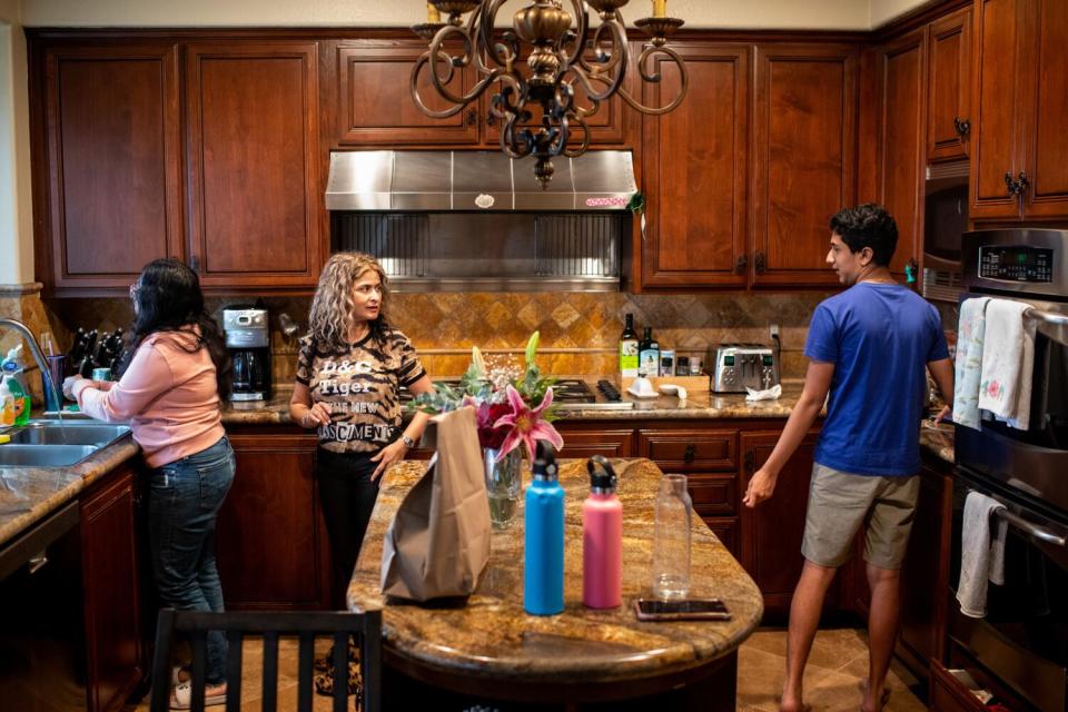 A mom and two children in a kitchen.