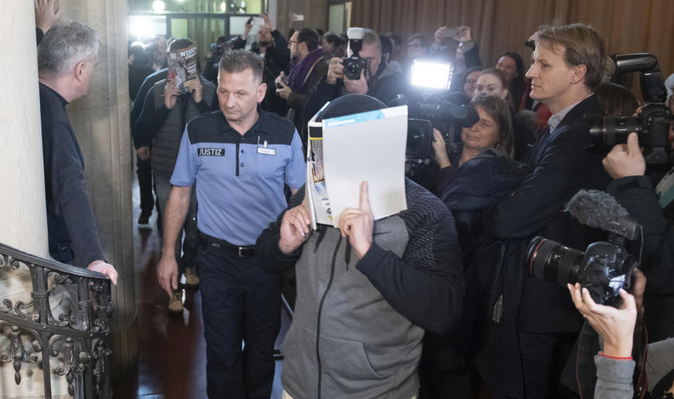 Un acusado cubre su rostro al llegar a una corte en Berlín, Alemania, el jueves 10 de enero de 2019 para el primer día del juicio contra cuatro jóvenes acusado de robar una moneda canadiense de oro de 100 kilos de un museo de Berlín en marzo de 2017. (Paul Zinken/dpa via AP)