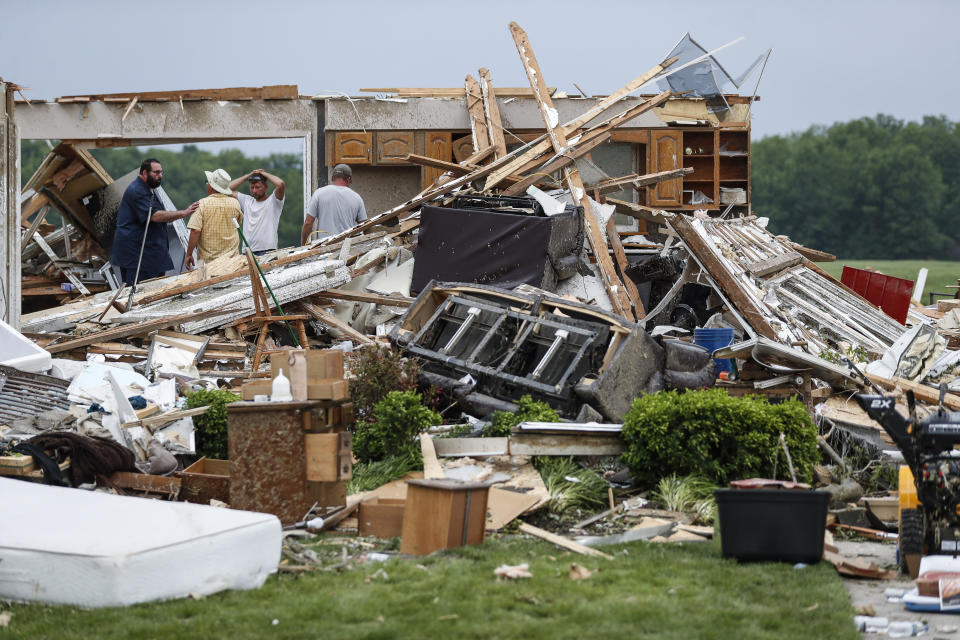 Residentes y voluntarios limpian escombros de viviendas dañadas en Fairground Road después de que un sistema de tornados pasó por el área la noche previa, el martes 28 de mayo de 2019, en Celina, Ohio. (AP Foto/John Minchillo)