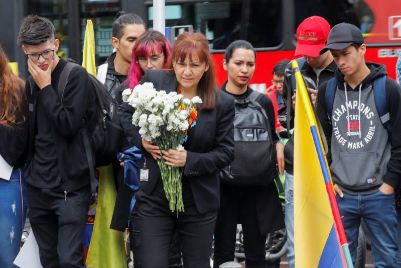 A person holds flowers during a gathering to honour Dilan Cruz, a teenage demonstrator who died after being injured by a tear gas canister during an initial strike last week, in Bogota