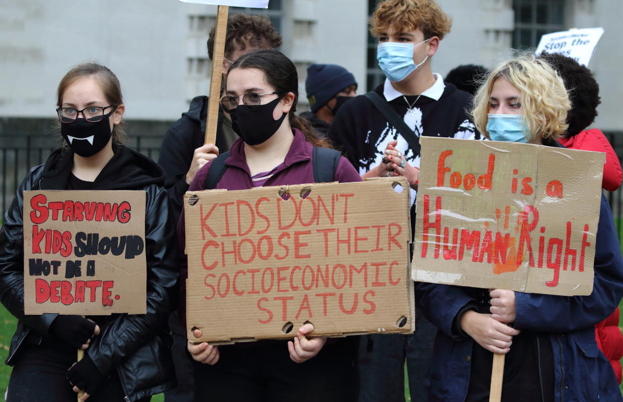  Youth wearing masks are seen holding placards during the protest against the decision to cut school meals. Youth protest outside Downing Street after the UK government MPs voted not to pay for school meals for under privileged children during half term. (Photo by Keith Mayhew / SOPA Images/Sipa USA) 