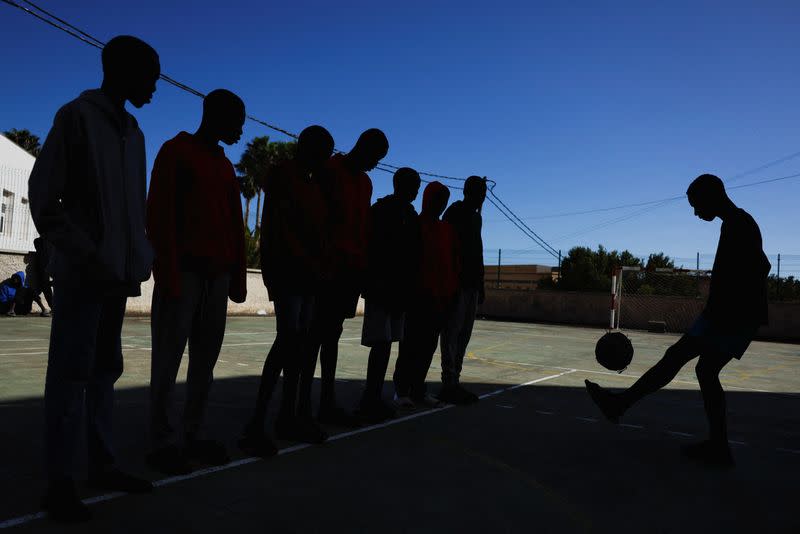 Several migrants minors play ball in the playground of the residence where they live in Valverde