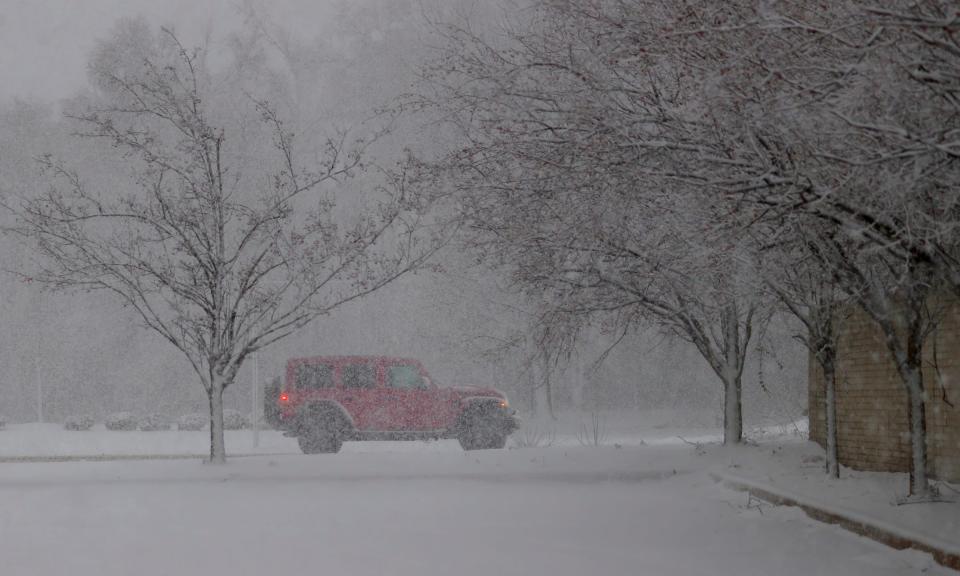 A vehicle heads north on Williams Lake Road in Waterford during Metro Detroit’s first winter storm of 2024