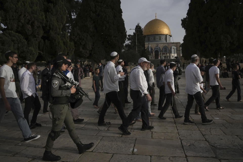 Israeli police escort Jewish visitors marking the holiday pf Passover to the Al-Aqsa Mosque compound, known to Muslims as the Noble Sanctuary and to Jews as the Temple Mount, in the Old City of Jerusalem during the Muslim holy month of Ramadan, Sunday, April 9, 2023. (AP Photo/Mahmoud Illean)