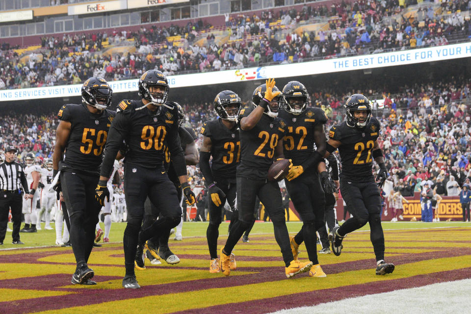 Washington Commanders cornerback Kendall Fuller (29) celebrating his interception against the Atlanta Falcons with his teammates near the end of the second half of an NFL football game, Sunday, Nov. 27, 2022, in Landover, Md. Washington won 13-19. (AP Photo/Jessica Rapfogel)