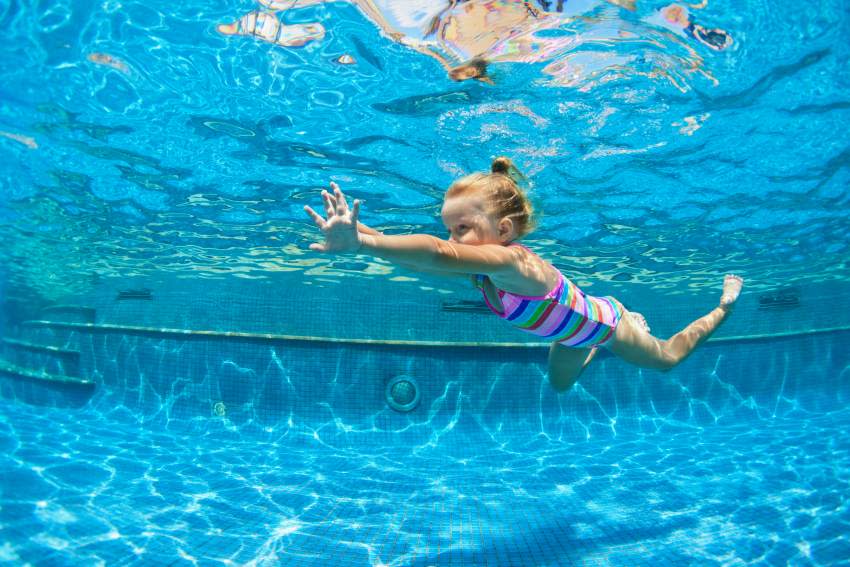 Niña nadando en la piscina