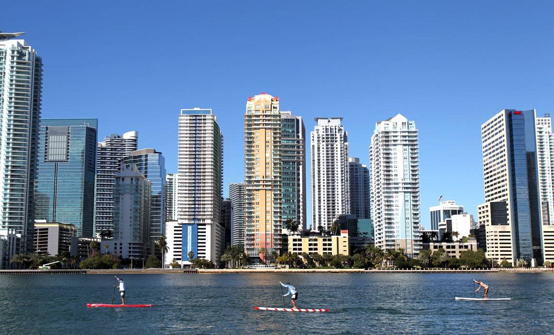 More condo terminations are on the rise. As a result, real estate analysts and lawyers predict South Florida’s skyline will change. Above: People ride paddle boards past Brickell, the county’s financial district. PATRICK FARRELL/MIAMI HERALD